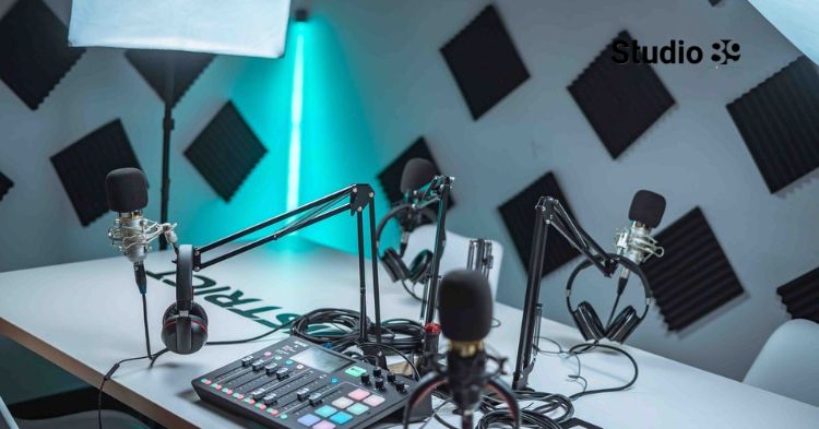 Podcast studio vs home setup in Dhaka showing a clean home-style podcast table setup with two microphones, laptop, headphones, coffee cups, and Studio89 logo